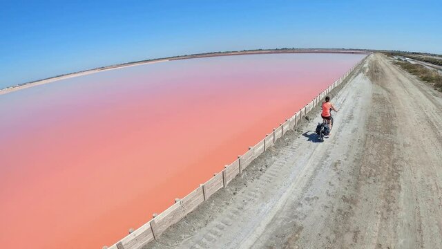 Une femme faisant du v&eacute;lo dans des marais salants
