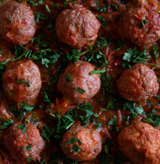 Turkey meatballs baked in the oven with herbs made by a girl according to a recipe from the Internet. Swedish meatballs cooking at home.