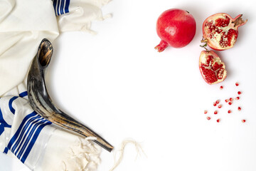 Talit, shofar, pomegranate and pomegranate seeds, on white background, top view
