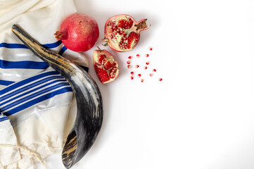 Talit, shofar, pomegranate and pomegranate seeds, on white background, top view. Rosh hashana