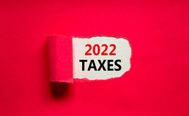2022 taxes new year symbol. Words '2022 taxes' appearing behind torn purple paper. Beautiful purple background. Business, 2022 taxes new year concept, copy space.