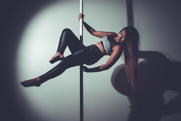 young asian woman doing pole dance at home