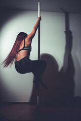 young asian woman doing pole dance at home