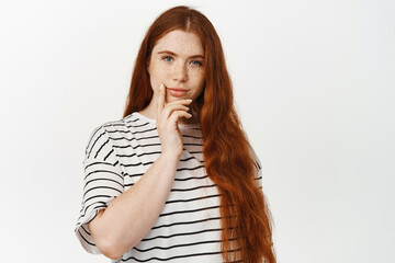 Image of young redhead girl with freckles thinking, looking with interest, pensive face, pondering...