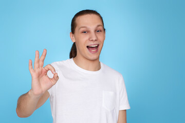 young handsome man in t-tshirt showing Ok gesture