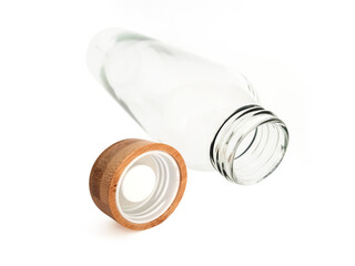 Empty Clear Glass Bottle with Wooden Lid in Horizontal Position on White Background. Close up of isolated reusable glass bottle. Ecological and biodegradable utensils and accessories.