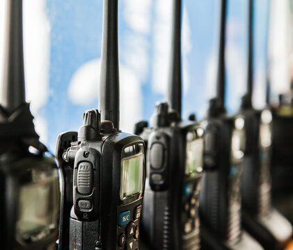 Many walkie-talkies stand in the chargers and charge.