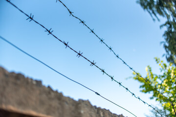 barbed wire over a concrete wall against the sky