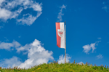 Austrian national flag waving in the wind against blue sky