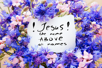 Jesus the name above all names - christian lettering with bouquet of blue cornflower and pink...