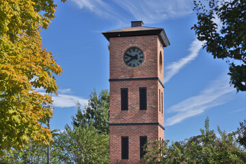 Old clock tower in autumn under blue sky