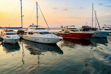 Sports private yachts are moored at the yacht club against the backdrop of the evening sky and...
