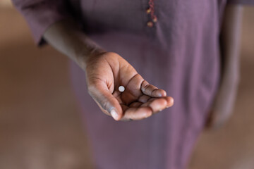 African Baby Boy holding medical pill or supplement in his hand to show treatment of deficiency. © Riccardo Niels Mayer