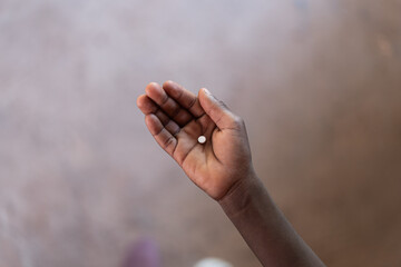 African Boy Holding Medicine Pill in his Hand to show Medical Treatment