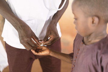 Getting pills to treat disease - Little African boy receiving vitamin from his African doctor © Riccardo Niels Mayer
