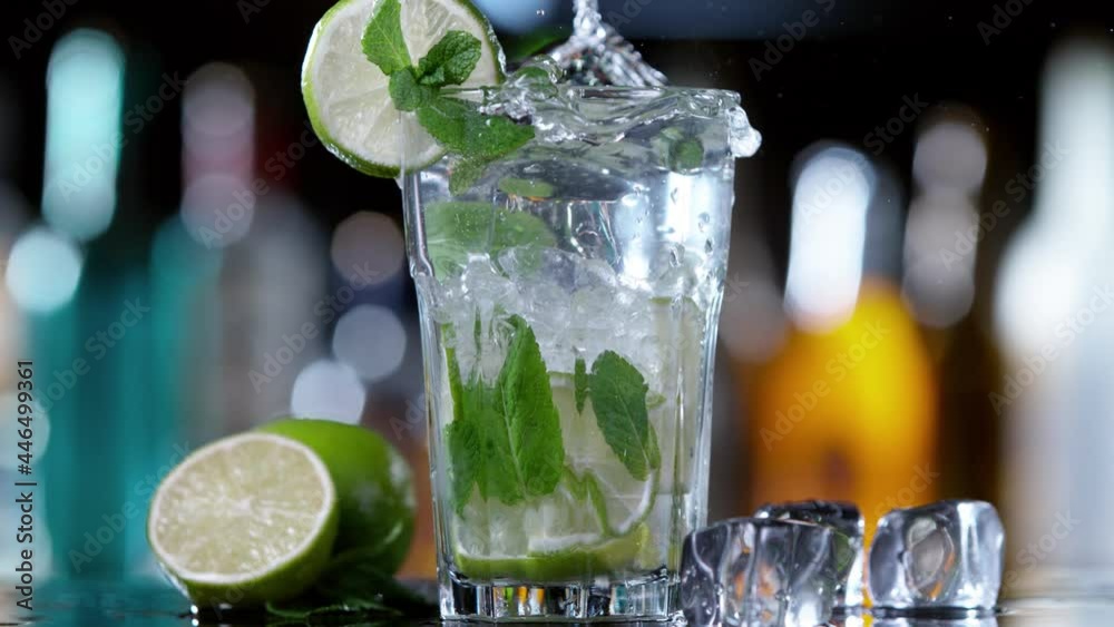 Poster super slow motion of falling ice cube into mojito drink, camera movement. speed ramp effect. filmed 