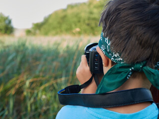 Caucasian girl photographing plant during forest excursion