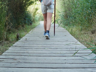 Caucasian girl feet on field trip on wooden path