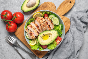 Fresh vegetable salad with grilled chicken. Ketogenic diet. Healthy food concept. Gray grunge background. Top view, flat lay.