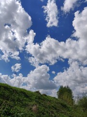 Obraz premium blue sky, clouds over the hill and forest