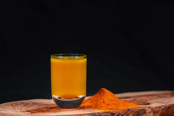 Leckerer Kurkuma-Drink serviert auf einem Holzbrett
