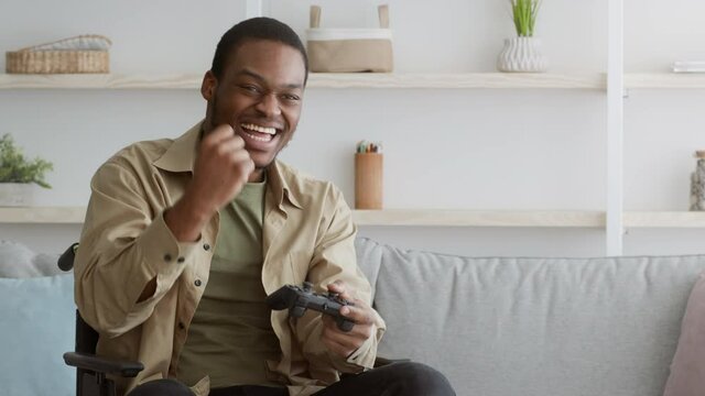 Joyful Disabled African American Man Playing And Winning Videogame Indoors