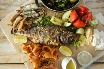Top view on the table full of served seafood and vegetable dishes
