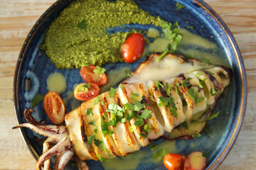 Grilled calamari with pesto sauce served in seafood restaurant