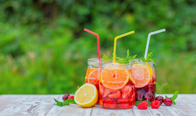 lemonade from berries on a table in the garden with a copy space.lemonade from berries on a table in the garden with a copy space. summer refreshing drink. tonic fruit detox water.