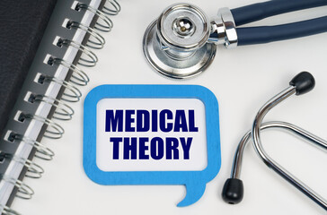 On the table is a stethoscope, a diary and a sign with the inscription - MEDICAL THEORY