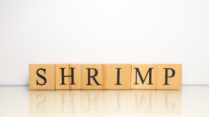 The name Shrimp was created from wooden letter cubes. Seafood and food.