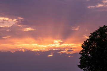 Moody orange sunset between the clouds sky