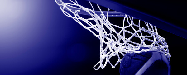 The orange basketball ball flies through the basket.  Blue color filter. Horizontal sport poster,...