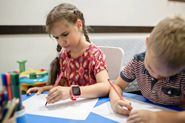 A lefty girl and righty boy writing at the same desk and nudge each other with elbows, international left-hander day celebration, only lefties understand