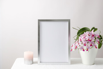 Floral card or poster mockup or silver photo frame in modern style with pink orchid flowers in the...