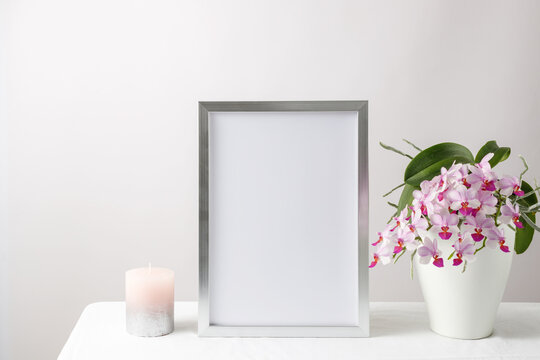 Floral card or poster mockup or silver photo frame in modern style with pink orchid flowers in the ceramic po