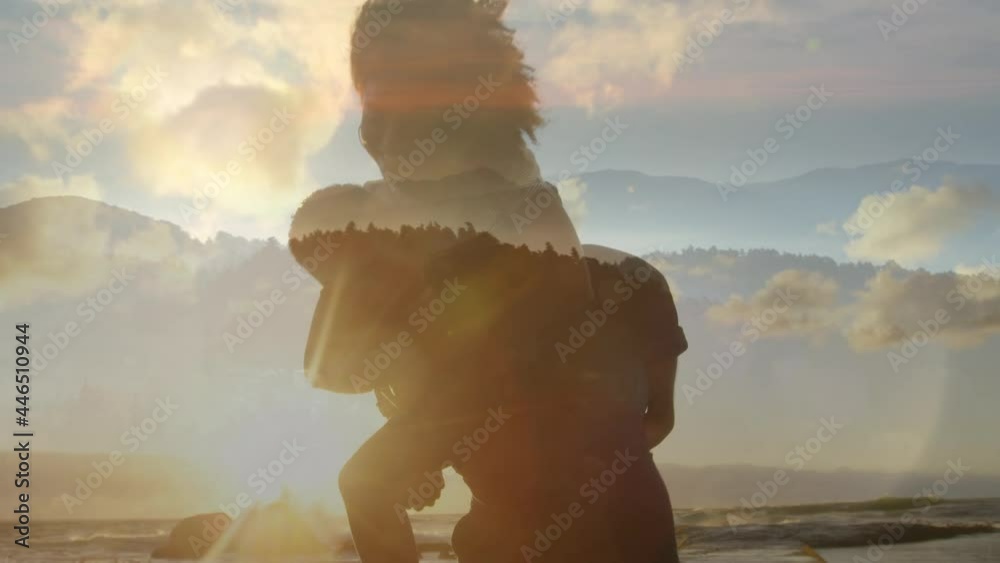 Wall mural Animation of happy african american couple having fun at beach over landscape