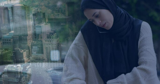 Animation of ssian woman in hijab using smartphone over cityscape