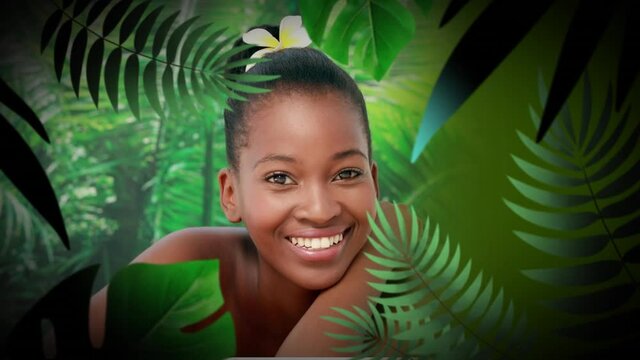 Animation of happy african american woman smiling in jungle, over leaves