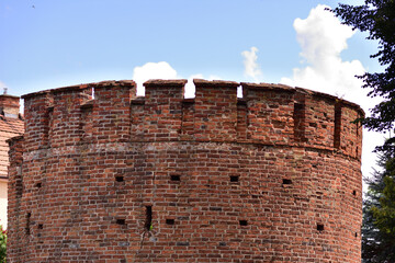 Medieval defensive tower against the sky and clouds. Summer. Day.