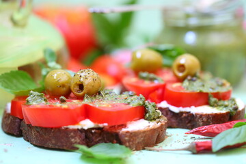 Bruschetta with cream cheese, tomatoes and pesto sauce