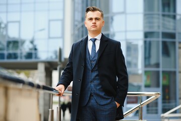 High fashion look.Young stylish confident handsome businessman model in suit clothes walking in the street.