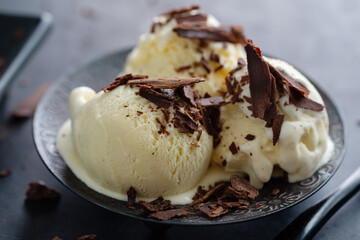 Vanilla ice cream scoops on dark plate