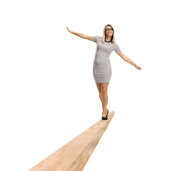 Full length portrait of a young woman walking on a wooden beam