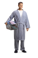 Young man in a bathrobe holding a laundry basket