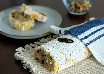 Delicioso pastel arroyado cubierto por servilleta de tela a rayas azul sobre mesa de madera artesanal.