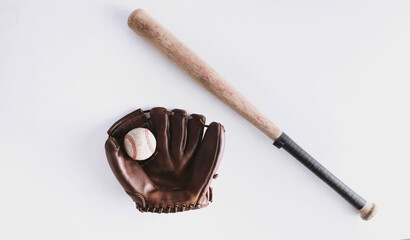 Sports equipment flat lay with top view of ball with leather glove and wooden bat, isolated on white background.