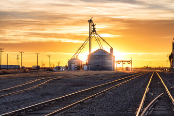 Grain silo and railroad tracks sunset