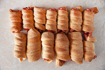 Sausage wrapped in dough, on a plate, fast food, close-up, top view