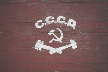 Soviet painted coat of arms. Hammer and sickle drawn on wooden boards